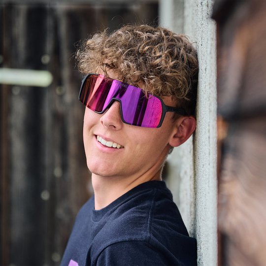 Athlet trägt EDDY Black Sunset Red – Sport Sonnenbrille mit Wechselgläsern für maximale Flexibilität.